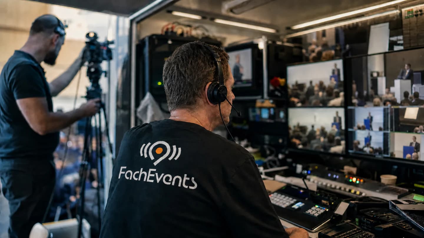 Atmosphärische FachEvents-Visualisierung: Crew mit sichtbarem Markenlogo in der Bildregie einer Liveproduktion