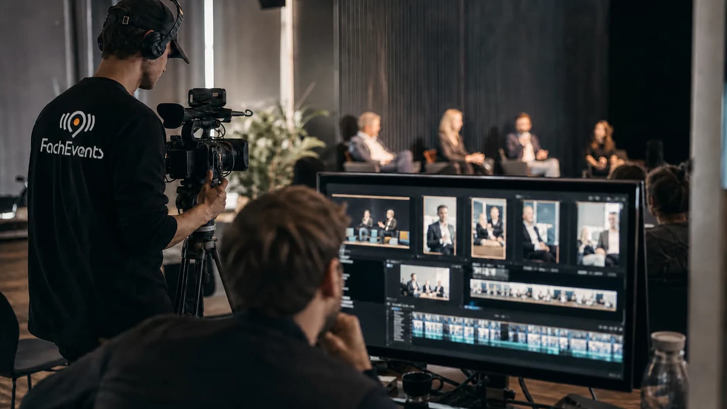 Atmosphärische FachEvents-Visualisierung: Kamerateam mit sichtbarem Markenlogo bei einer Eventvideo-Produktion